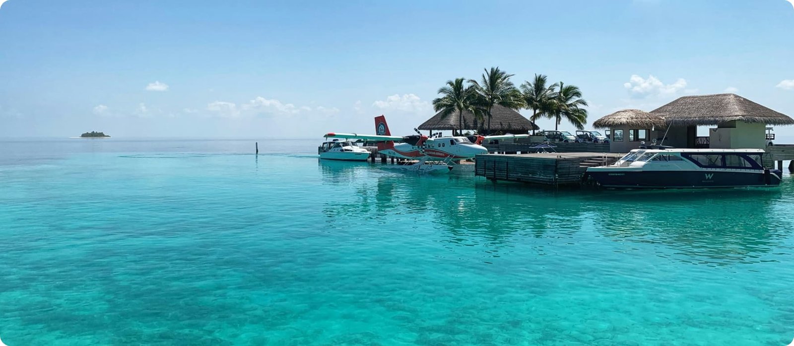 Seaplane docked at a luxury island resort surrounded by turquoise waters